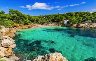 Eine Bucht mit türkisfarbenem Wasser und einem Sandstrand.