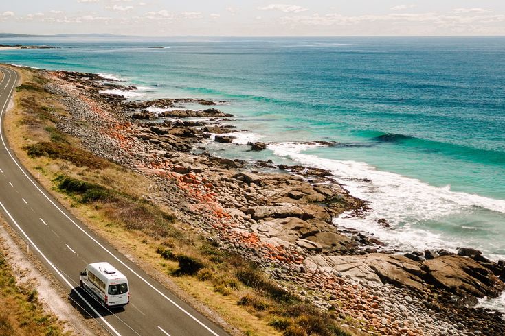 Camper fährt entlang einer Straße am Meer in Australien 