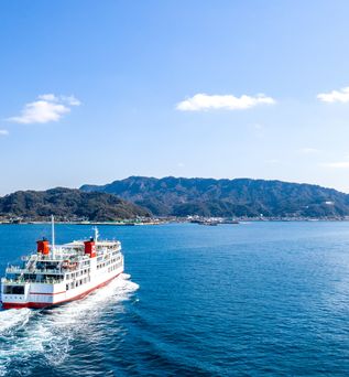 Kreuzfahrtschiff fährt durch das Meer mit Berg im Hintergrund