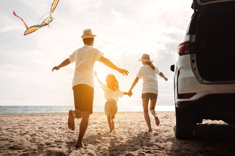 Eine Familie am Strand, die sich der Kamera zuwendet.
