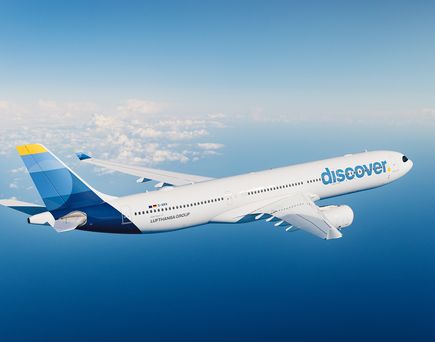 Discover Airlines Flugzeug in luftiger Höhe über dem Atlantik bei Tageslicht. 