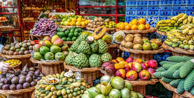 Ein bunter Marktstand mit vielen Früchten und Gemüse.