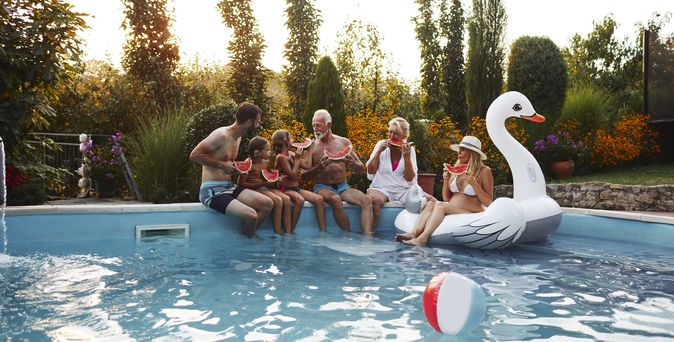 Familie sitzt am Poolrand