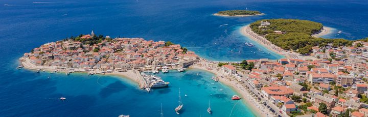 Eine Luftaufnahme einer Küstenstadt mit einer Insel und dem Meer.