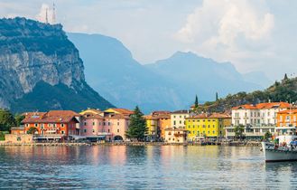 Eine Stadtansicht am See mit Gebäuden und Bergen.