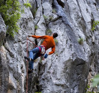 Eine Person klettert an einem Felsen hinauf.