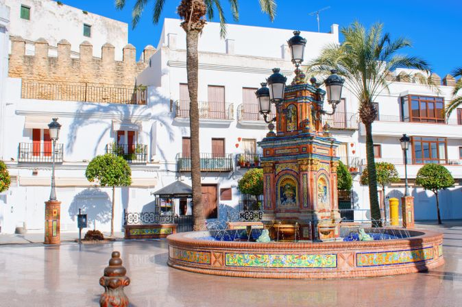 Eine historische Gasse mit einem Torbogen und Gebäuden in einer mediterranen Stadt.
