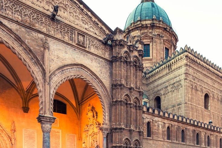 Ein historisches Gebäude mit einem Torbogen und einer Kathedrale.