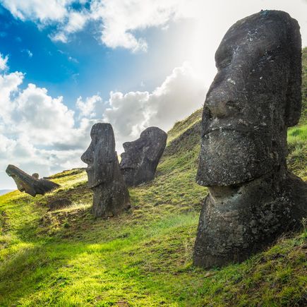 Profilansicht einer Reihe von Moai-Statuen, den berühmten monolithischen Figuren der Osterinsel, die auf einem Hügel im Rano Raraku Steinbruch stehen.