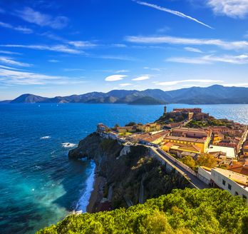 Panoramablick auf Portoferraio auf Elba mit der Festung, dem Hafen und dem klaren blauen Meer unter strahlendem Himmel.