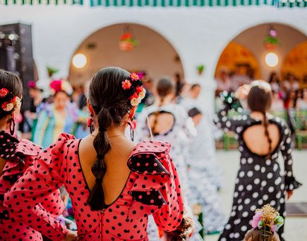 Spanische Frauen von hinten in typischen Flamenco Kleidern 