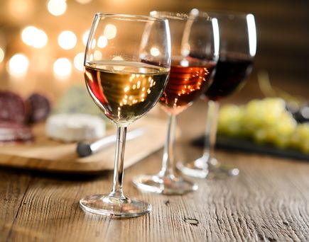 Zwei Gläser Rotwein und eine Flasche auf einem Tisch.