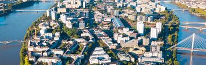 Eine Luftaufnahme einer Stadt mit einem Fluss und einem Schloss.
