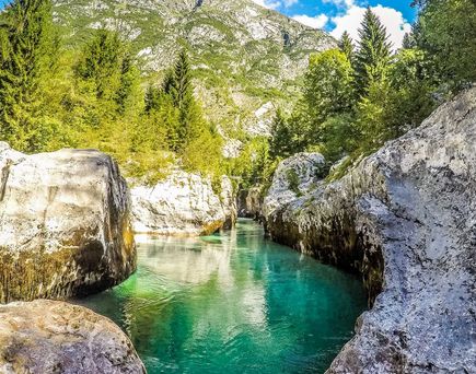Der Soča Fluss in Slowenien mit seinem klaren türkisfarbenen Wasser, das sich durch eine felsige Schlucht schlängelt.