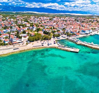 Eine Panoramaansicht von Novalja, Kroatien, mit der Stadt und dem Meer.