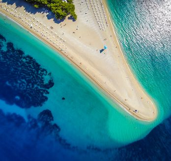 Ein Sandstrand mit türkisfarbenem Wasser.