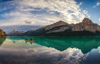 Zwei Männer im Kanu auf dem Maligne Lake vor sagenhafter Bergkulisse