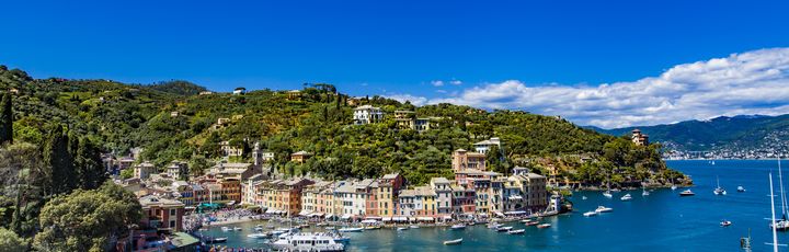 Luftaufnahme der malerischen Hafenstadt Portofino in Ligurien, Italien, mit bunten Häusern und Yachten im klaren Wasser.
