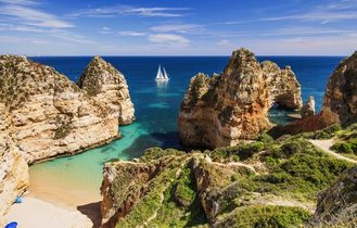 Die beeindruckenden Klippen von Benagil an der Algarveküste, Portugal, mit ihren bizarren Felsformationen und Höhlen, die von türkisfarbenem Wasser umspült werden.