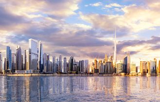 Eine weite Panoramaansicht der ikonischen Skyline von Dubai, mit dem Burj Khalifa und dem Burj Al Arab, die sich majestätisch über die Stadt erheben.