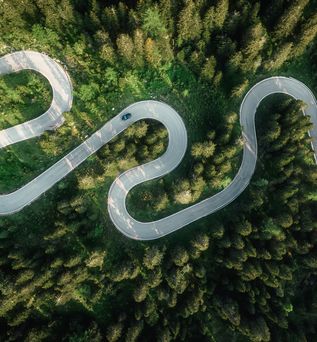 Kurvenreiche Straße im Grünen aus der Vogelperspektive