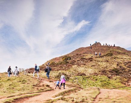 Zwei Personen wandern auf einem Hügel.