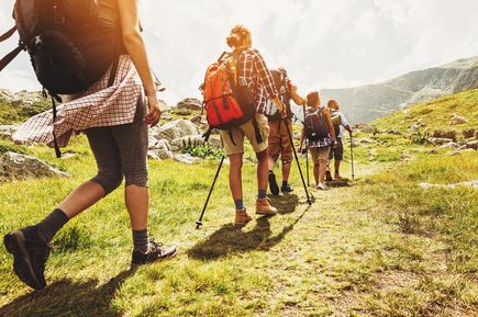 Personen wandern auf einem Weg in den Bergen.