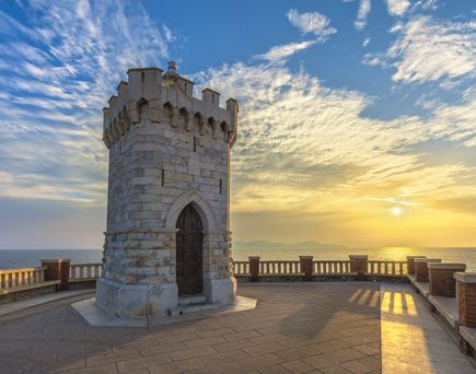 Ein Leuchtturm auf einer Klippe bei Sonnenuntergang.