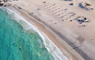 Eine Luftaufnahme eines Strandes mit türkisfarbenem Wasser.
