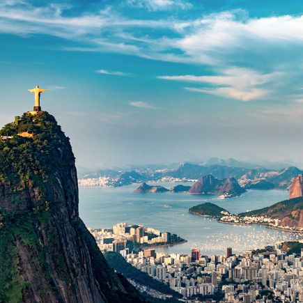 Die Christusstatue thront auf dem Corcovado in Rio de Janeiro, Brasilien, mit dem Zuckerhut und der weiten Stadtlandschaft im Hintergrund.