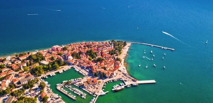 Eine Luftaufnahme der Stadt Novigrad in Istrien, Kroatien, mit Gebäuden, die ins Meer ragen.