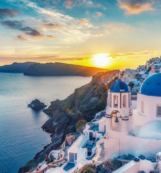 Schöner Ausblick bei Sonnenuntergang über weiß getünchte Häuser mit blauen Dächern