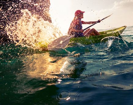 Eine Person in einem Kajak auf dem Wasser.