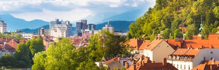 Eine Stadtansicht von Ljubljana, Slowenien, mit einem Fluss und bunten Gebäuden.