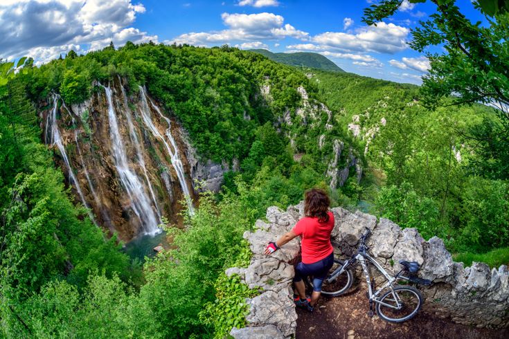 Radfahrerin schaut auf den Wasserfall plitvicer Seen