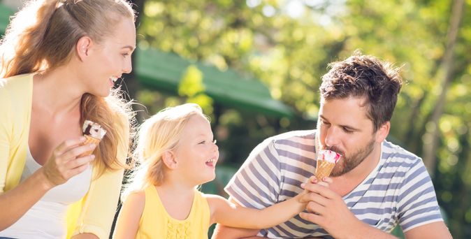 Mutter, Tochter und Vater während des Eis essens.