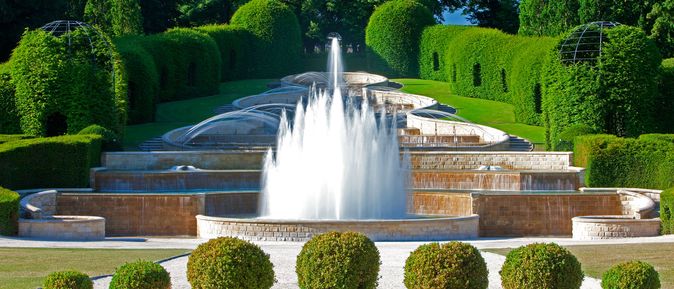 Ein Brunnen vor einem Schloss.