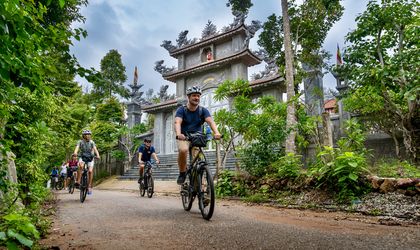 Mehrere E-Bike Fahrer in Vietnam vor einem Tempel