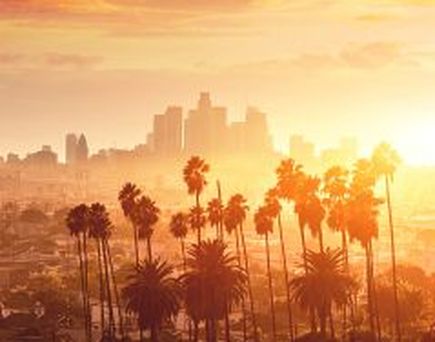  Die Skyline von Los Angeles bei Sonnenuntergang, mit der Stadt, die sich unter einem farbenfrohen Himmel erstreckt.