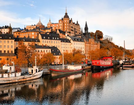 Malerische Küstenstadt in Schweden mit bunten Häusern am Wasser und Booten.