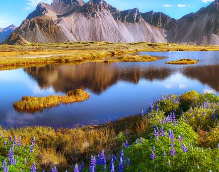 Island mit Bergen im Hintergrund und Wasser im Vordergrund
