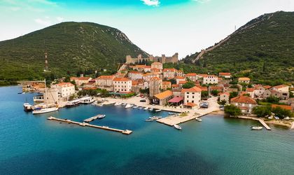 Eine Luftaufnahme einer Küstenstadt mit einem Hafen und Bergen.