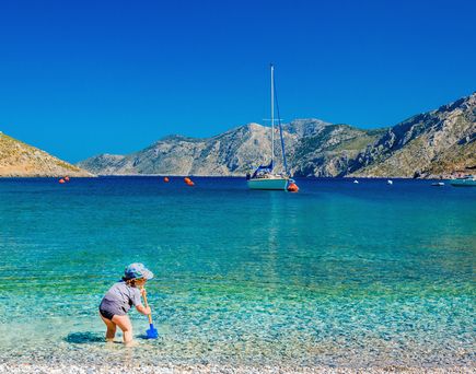 Kleines Kind badet im Meer in Griechenland