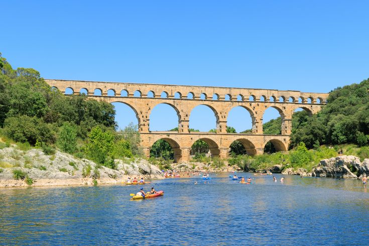 Blick vom Fluss auf Pont du Gard. Auf dem Waser Kanu Fahrer.