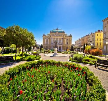 Ein Platz mit einem Brunnen und einem historischen Gebäude.