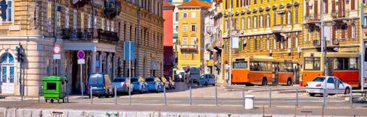 Eine Stadtansicht mit Gebäuden, die sich im Wasser spiegeln, und Booten.