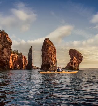 Ein Mann im gelben Kajak macht eine Tour an den Three Sisters