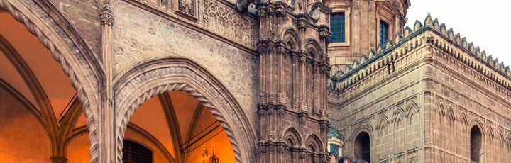 Ein historisches Gebäude mit einem Torbogen und einer Kathedrale.