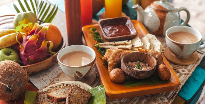 Maledivischer Afternoon Tea mit Chai-Tee, Short Eat Snacks, Obst und Kokosnuss-Mashuni