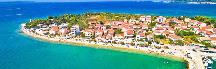 Eine Luftaufnahme einer Küstenstadt mit einer Insel und dem Meer.